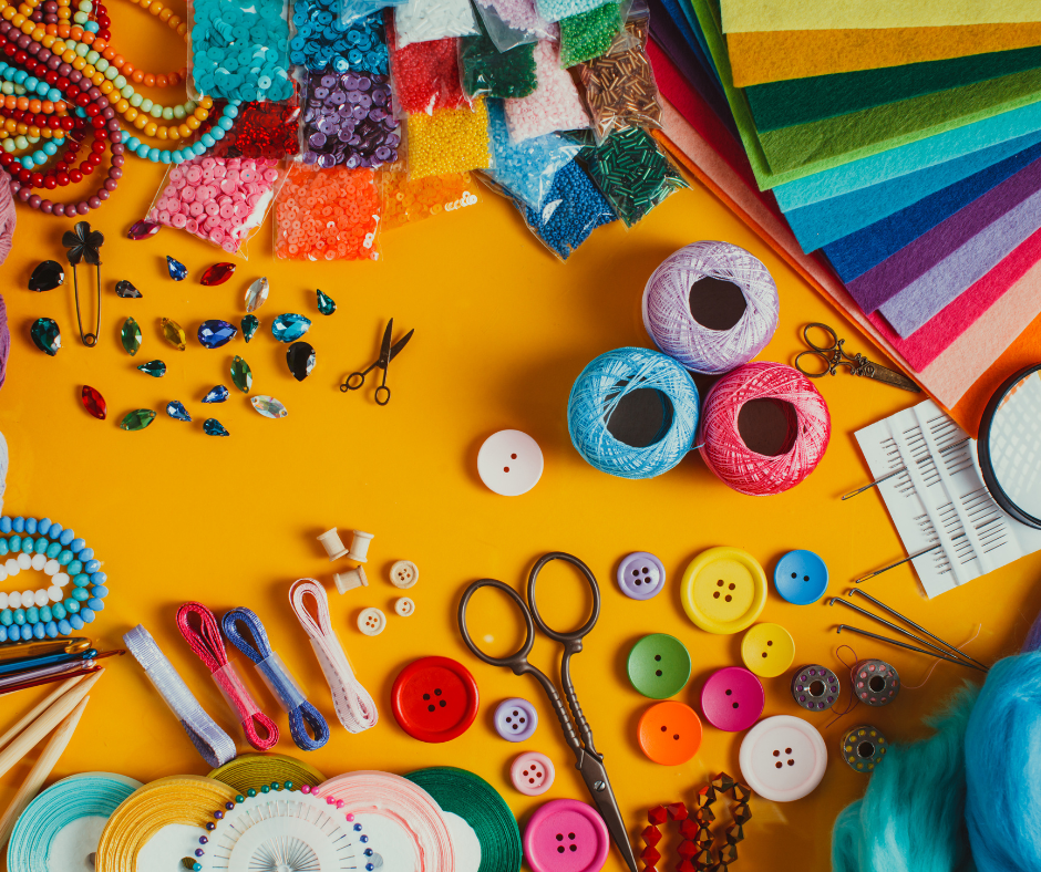 various craft supplies such as buttons, felt, paper, and sequins on a yellow background