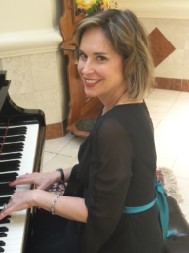 Performer Robyn Vitson sitting at a piano