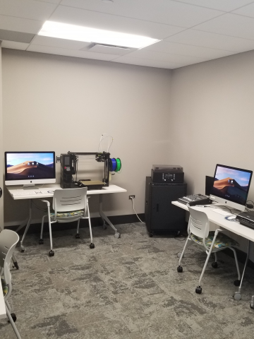 Picture of the Digital Media Lab room with table, chairs, and computers.