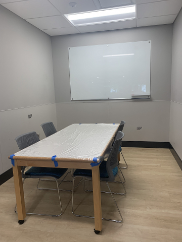 Picture of library study room with table, chairs, and dry erase board.