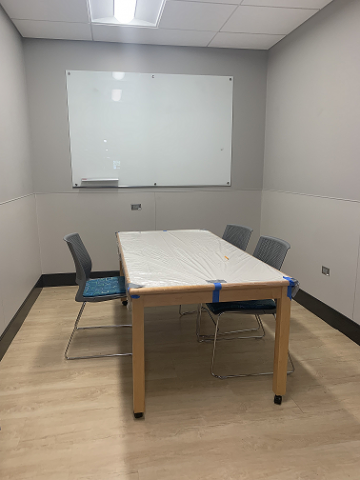 Picture of library study room with table, chairs, and dry erase board.