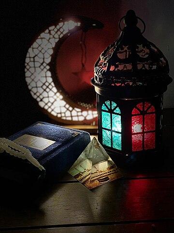 Ramadan symbols on table: lantern + crescent moon