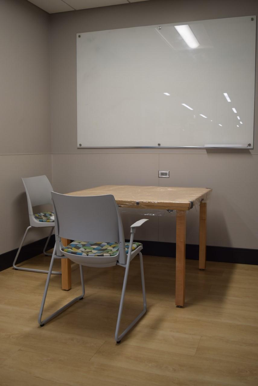 Picture of library study room with table, chairs, and dry erase board.